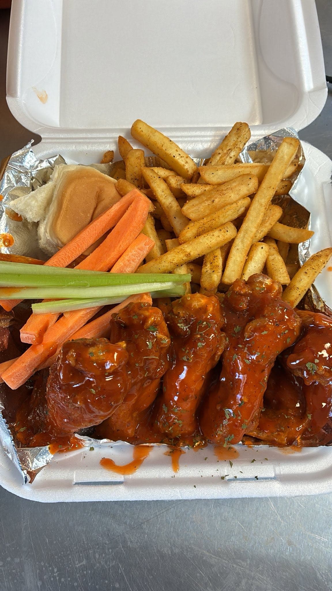 Wings, fries and veggies in a box